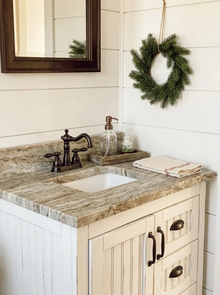 Farmhouse Christmas bathroom decor with a small wreath, neutral towels, and a wooden vanity tray.